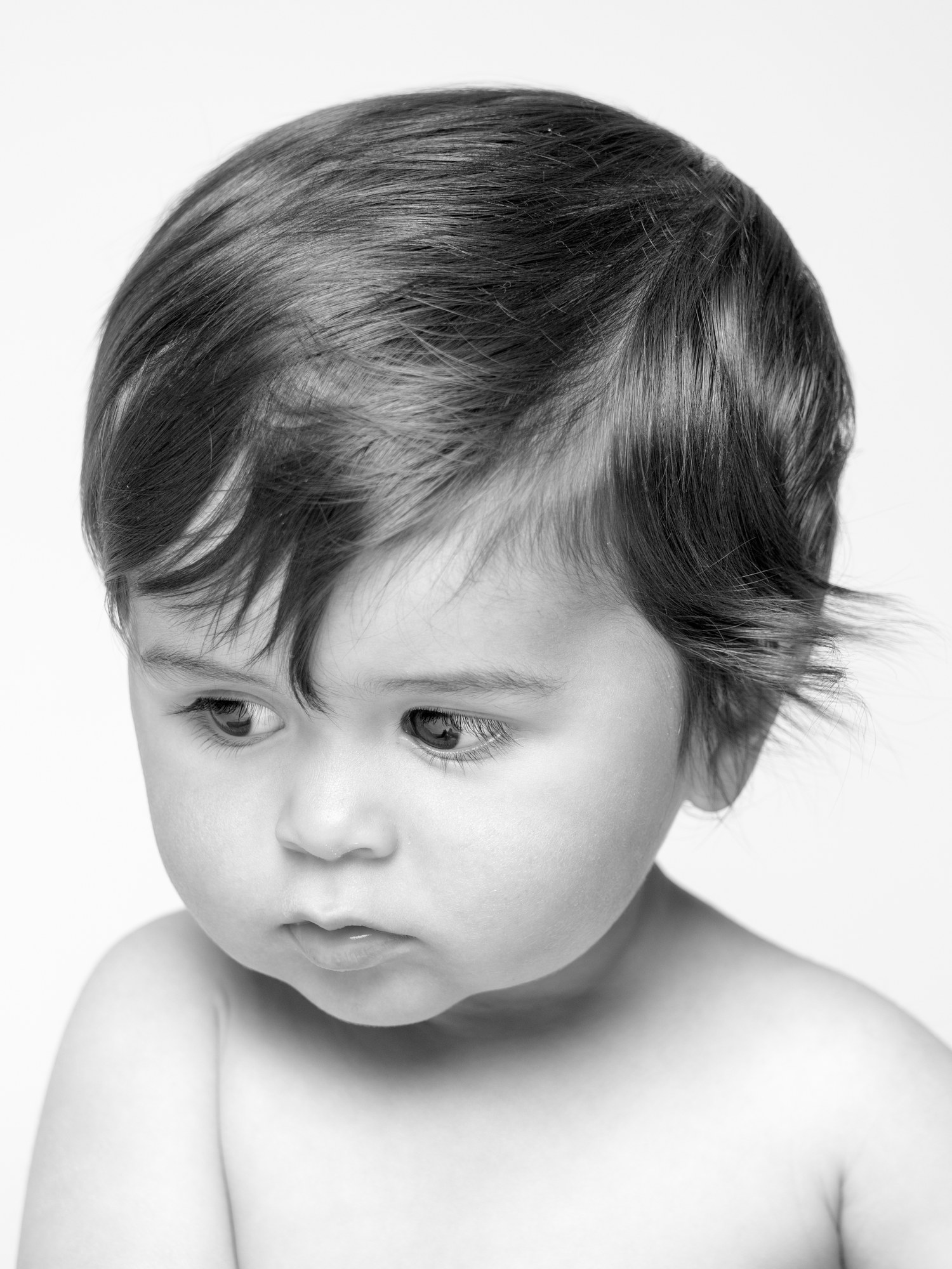 Thoughtful baby looking down, black and white