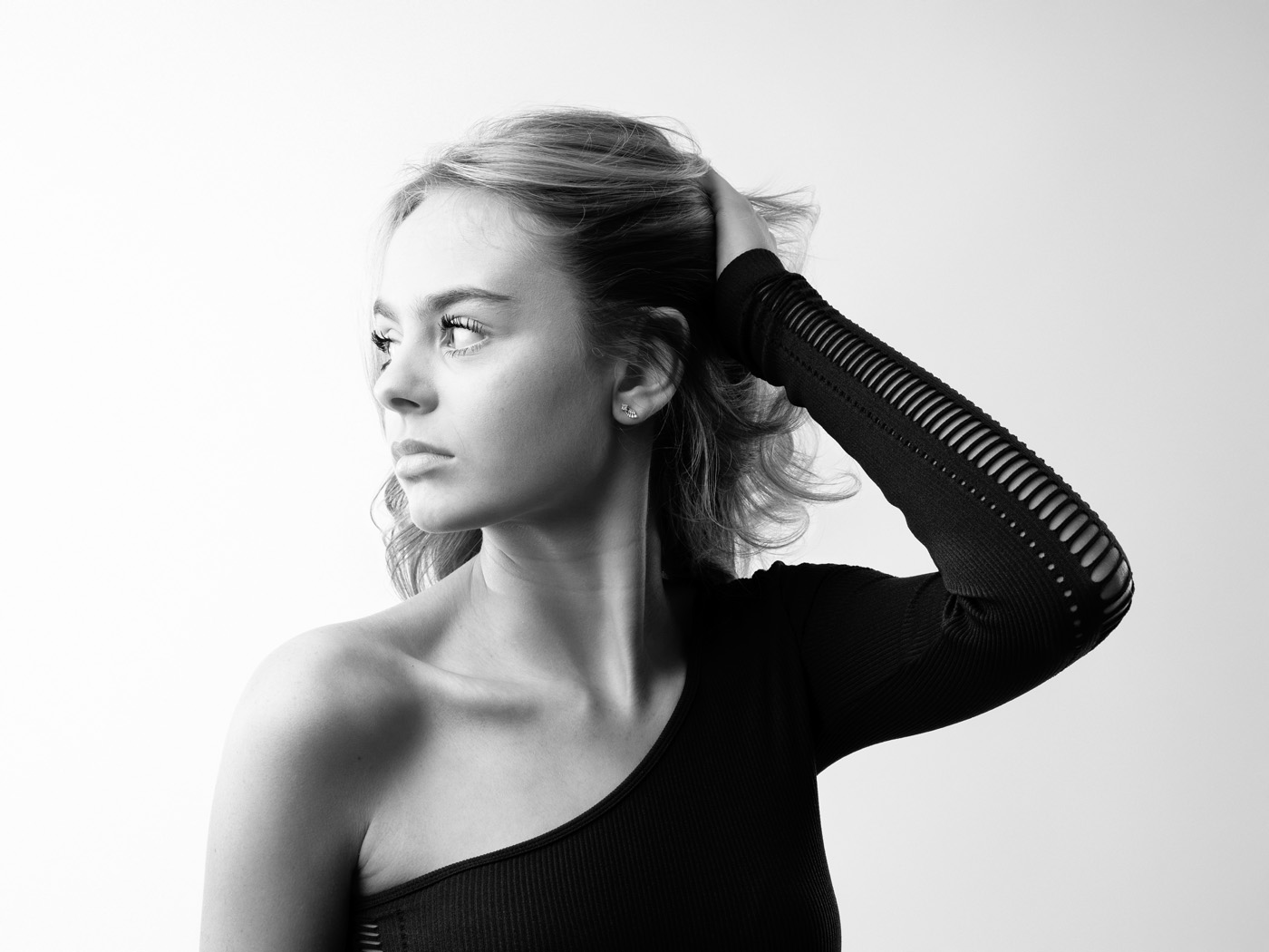 Teenage girl with a hand in her hair looking away, black and white