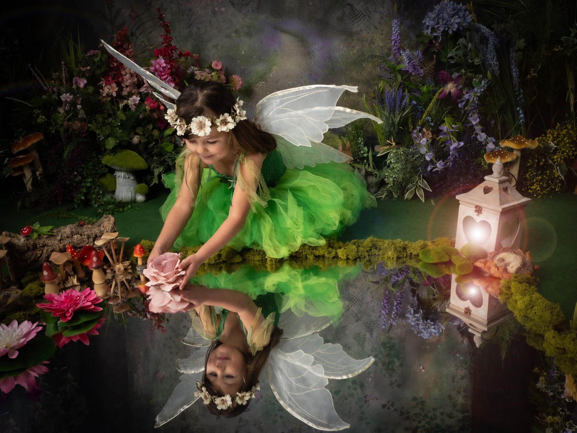 Fairy in green reaching into a reflecting pool