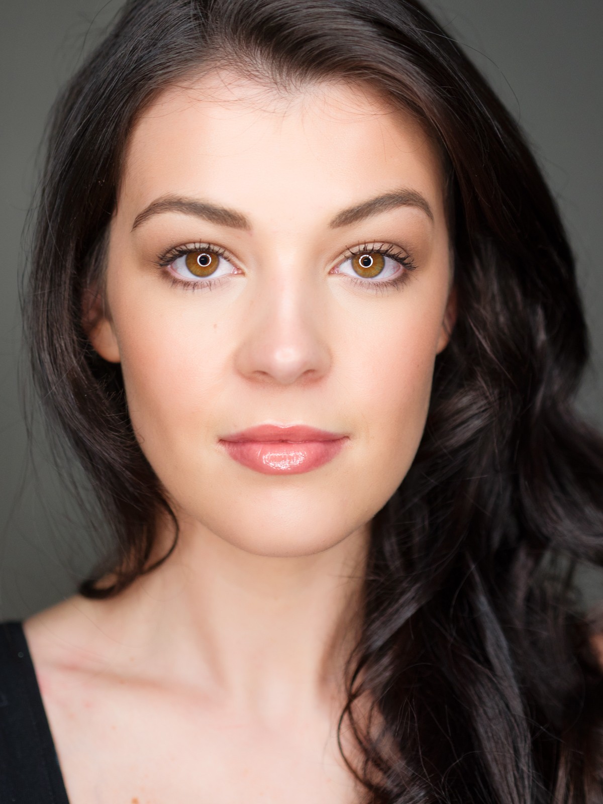 Close-up headshot of a woman with long dark hair and brown eyes