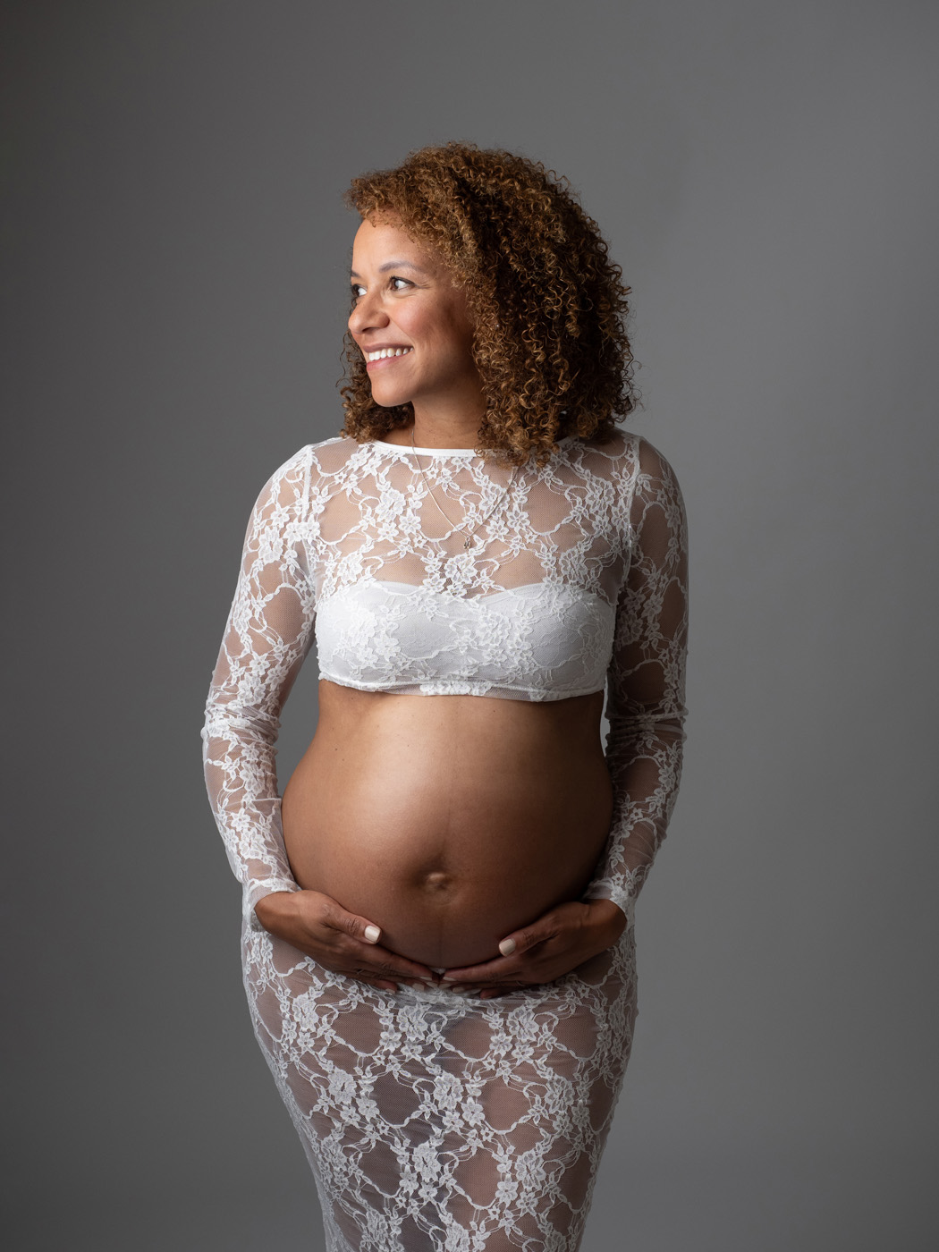 Smiling mum-to-be in a white lace gown