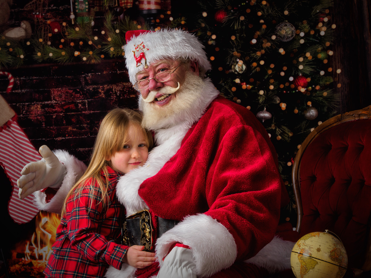 Girl cuddling up to Santa
