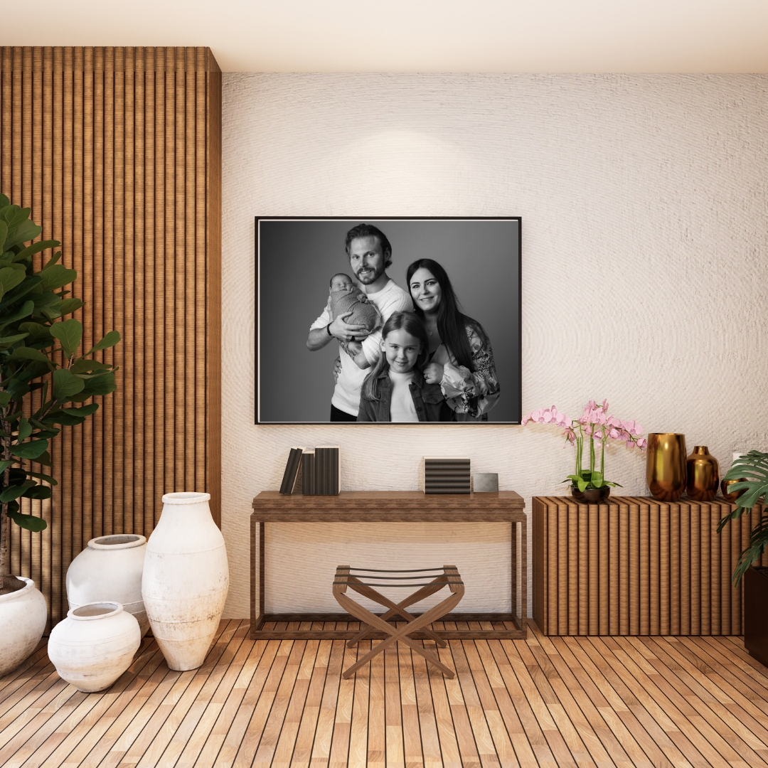 Black and white family portrait framed above a console table