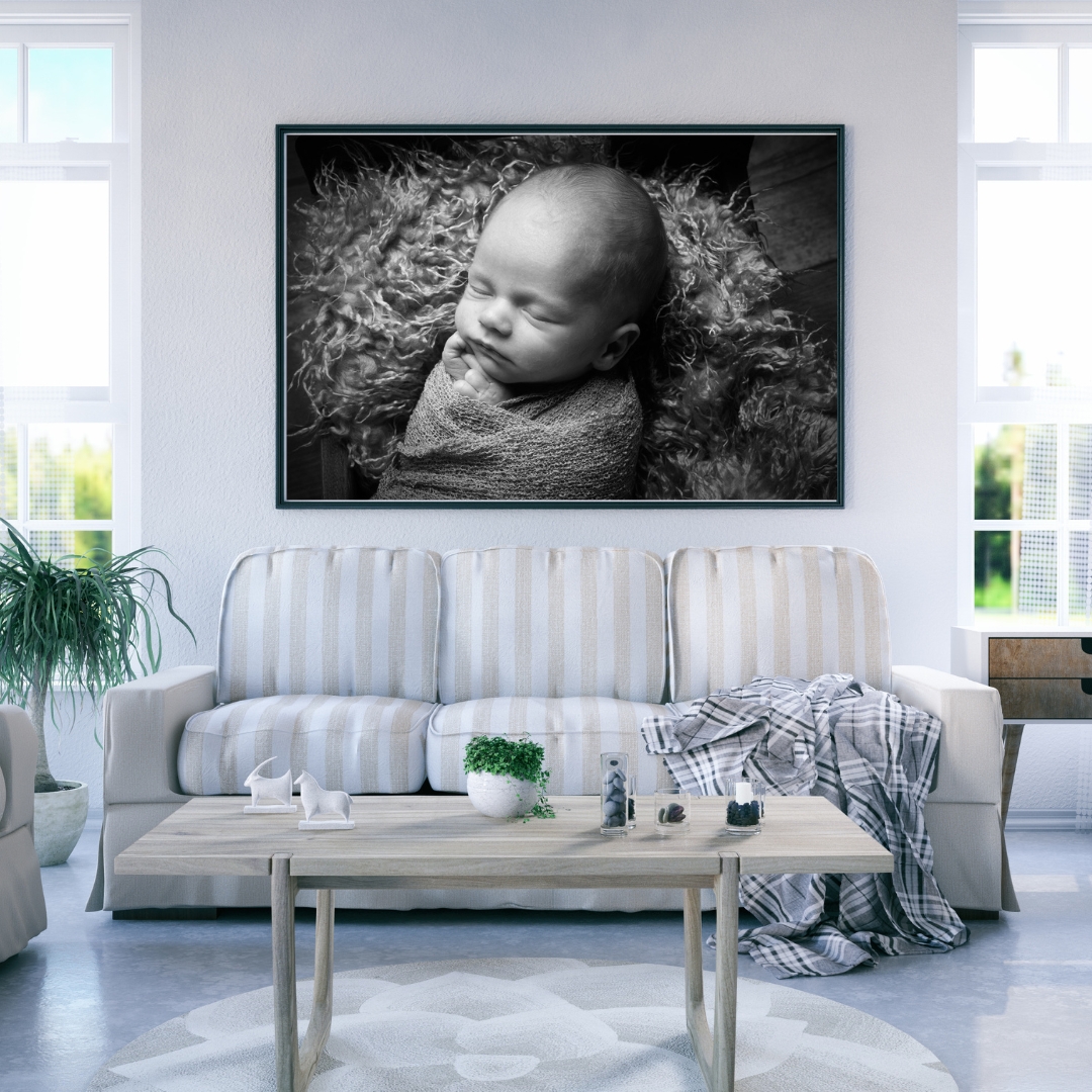 Large black and white newborn portrait above a sofa