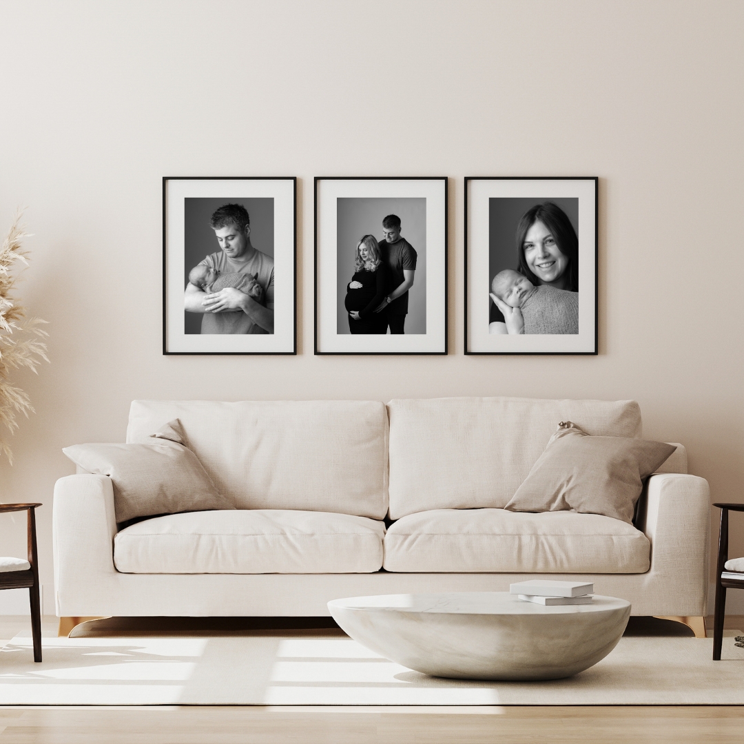 Three framed black and white portraits above a cream sofa
